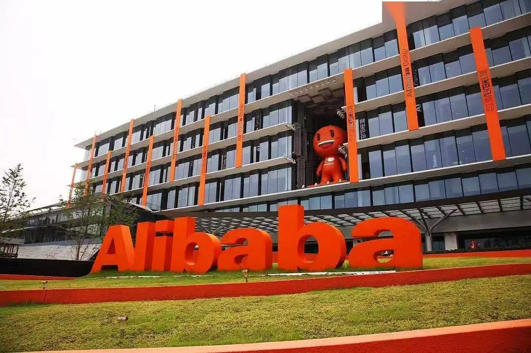 橙色 Alibaba 立体标识前的玻璃幕墙办公楼